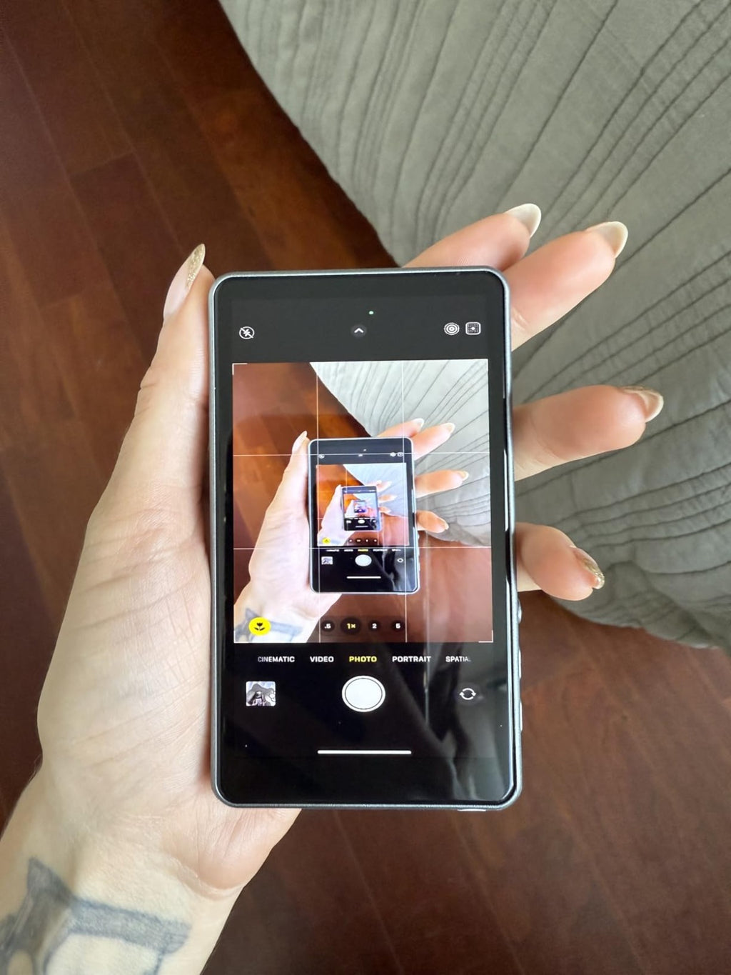 Persona sosteniendo el celular con el Selfie Pantalla pegado, encuadrando una foto con la cámara trasera